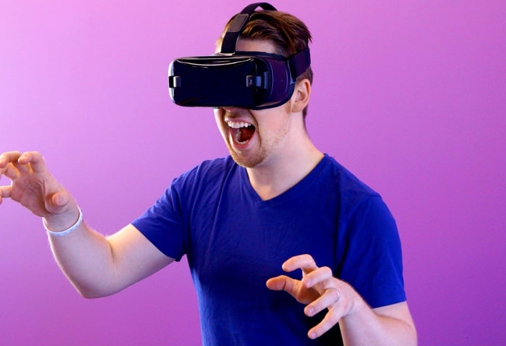 A guy in blue shirt using VR glasses.